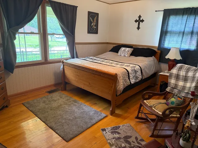 a bedroom with a bed and wooden floor