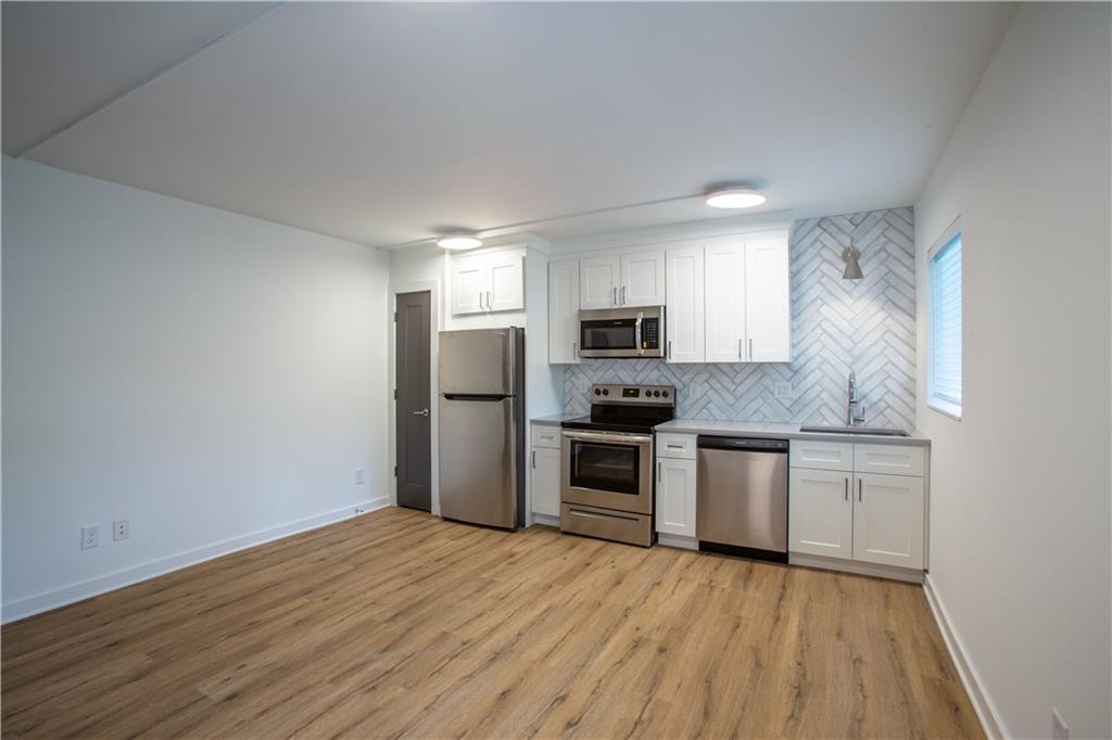 41 25th Street Northwest, Unit 5 Atlanta, GA 30309 - Photo 3 of 15 a kitchen with granite countertop a refrigerator stove and sink