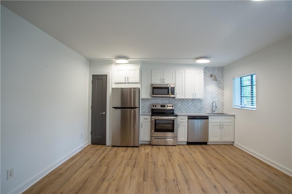 41 25th Street Northwest, Unit 5 Atlanta, GA 30309 - Photo 8 of 15 a kitchen with stainless steel appliances a refrigerator and a stove top oven