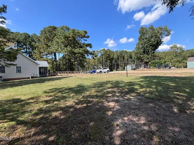 a view of a yard with large trees