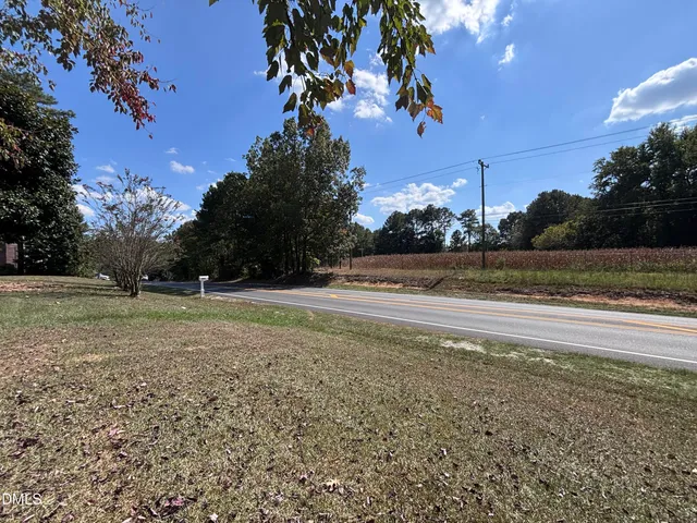 a view of a tennis ground with large trees