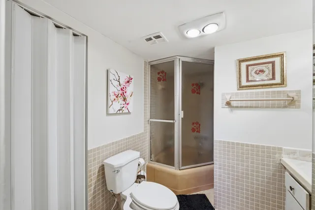 a kitchen with stainless steel appliances kitchen island granite countertop a sink dishwasher stove and refrigerator with wooden floor