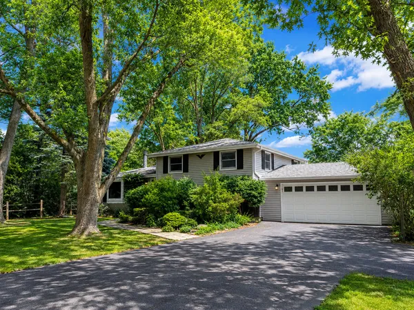 a front view of a house with a yard and tree s