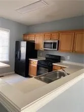 a kitchen with granite countertop a refrigerator and a sink