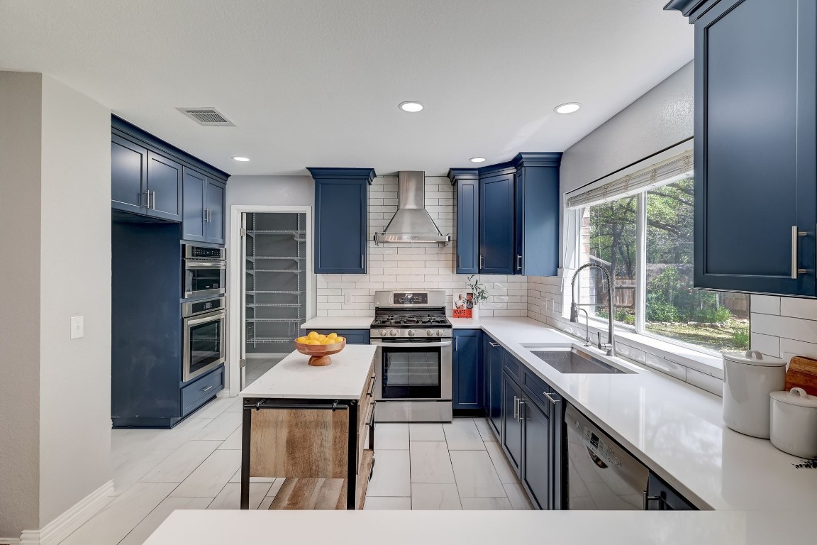 a kitchen with stainless steel appliances granite countertop a stove top oven a sink and dishwasher