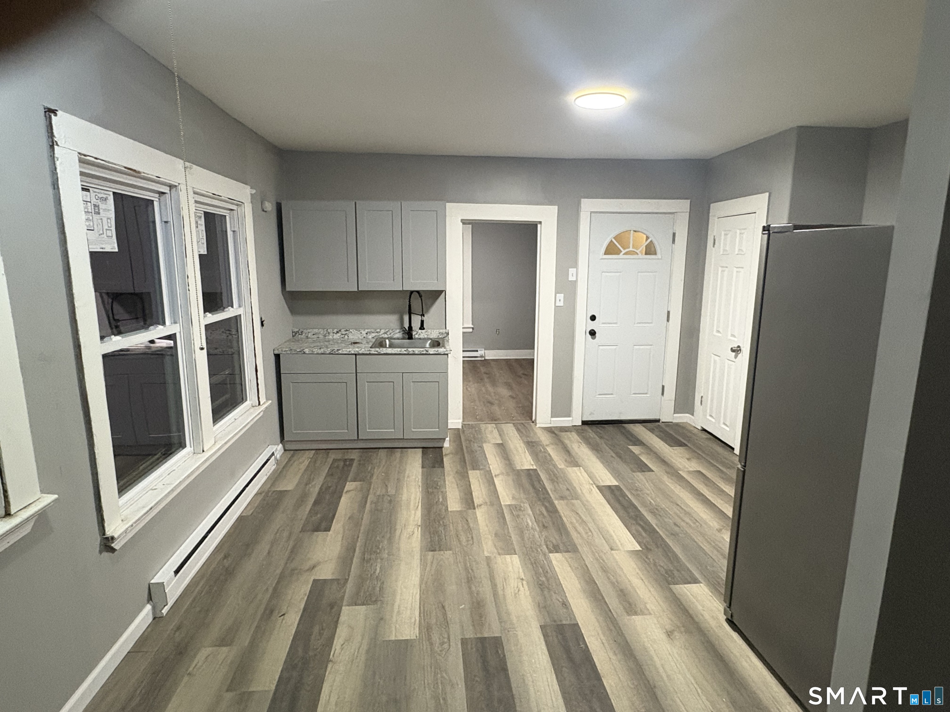 89 Birch Street Manchester, CT 06040 - Photo 1 of 5 a view of a kitchen with refrigerator stove and wooden floor