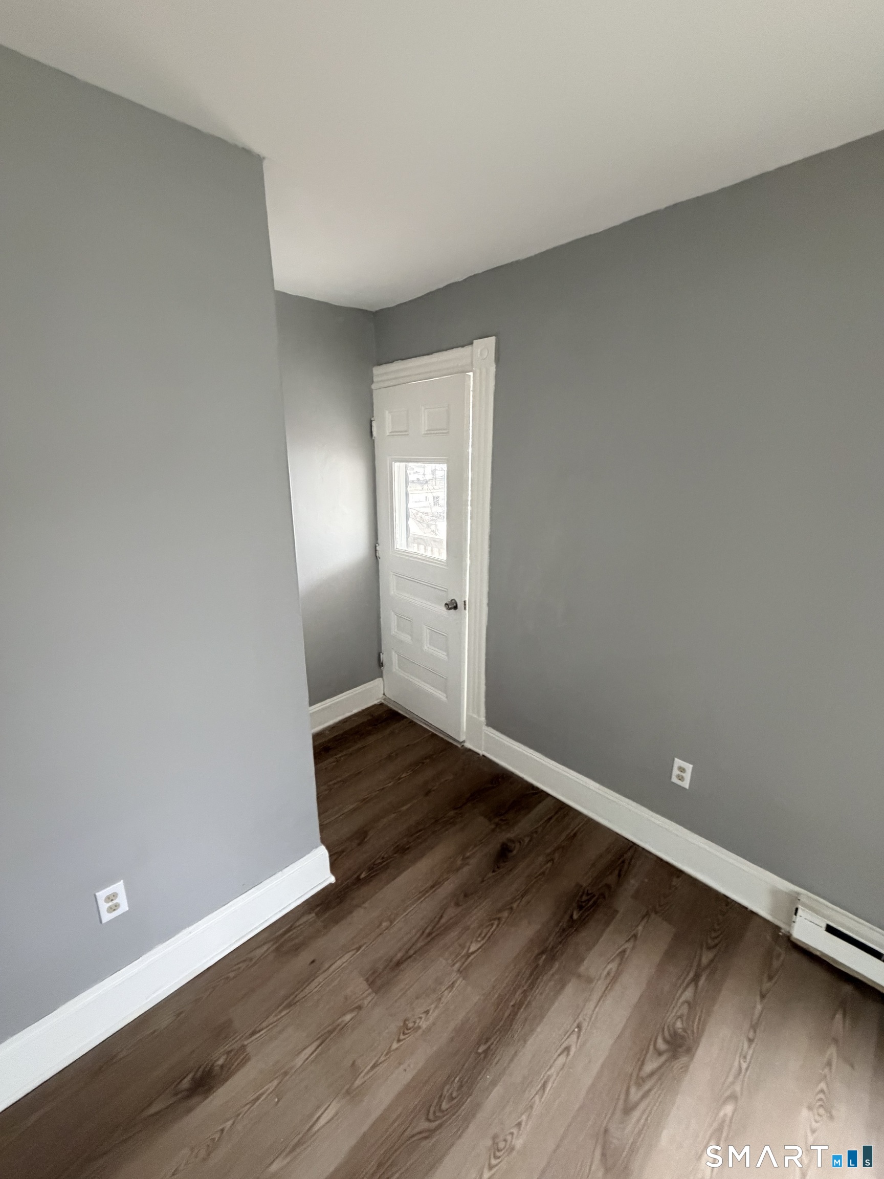 89 Birch Street Manchester, CT 06040 - Photo 4 of 14 a view of an empty room with wooden floor and a window