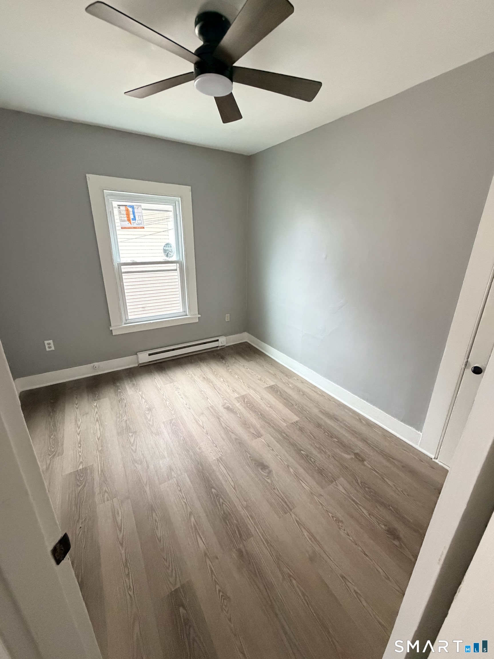 89 Birch Street Manchester, CT 06040 - Photo 8 of 14 an empty room with wooden floor fan and windows