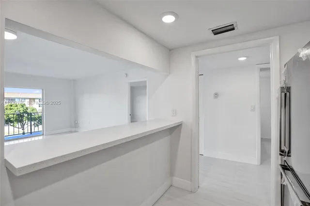 a kitchen with white cabinets stainless steel appliances and sink