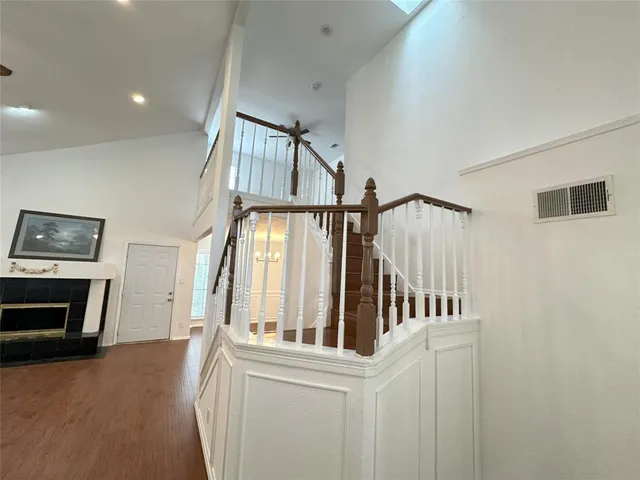 a view of staircase and kitchen with wooden floor