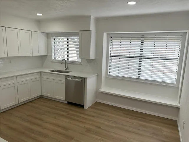 a view of a kitchen with a sink cabinets and wooden floor