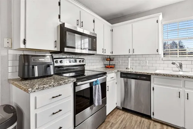 a kitchen with stainless steel appliances granite countertop a sink stove and microwave