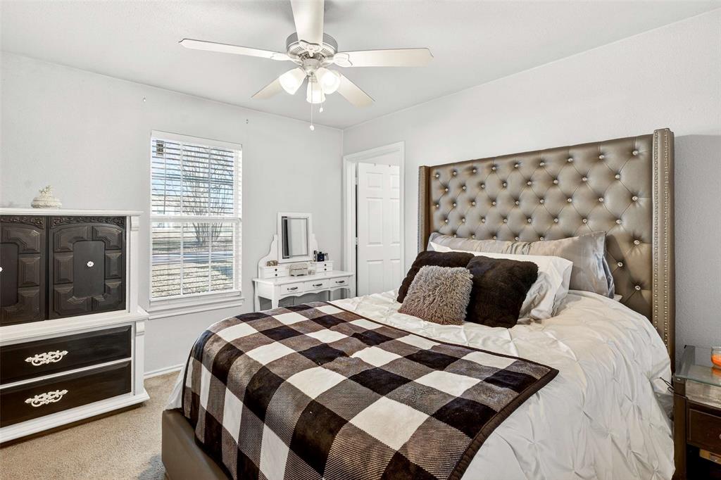 1001 South 4th Street Bonham, TX 75418 - Photo 14 of 27 a bedroom with a bed and a flat tv screen on dresser