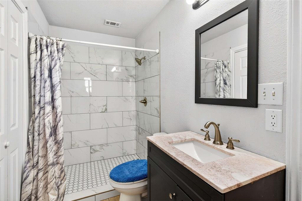 1001 South 4th Street Bonham, TX 75418 - Photo 16 of 27 a bathroom with a sink toilet and a mirror