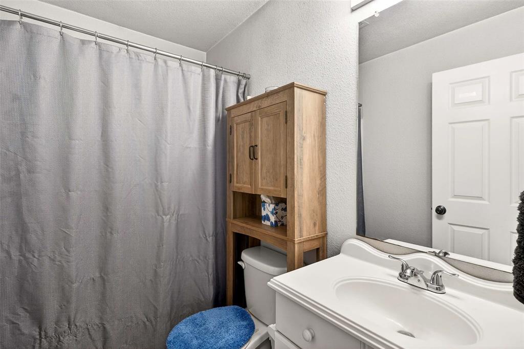 1001 South 4th Street Bonham, TX 75418 - Photo 17 of 27 a bathroom with a sink and a mirror