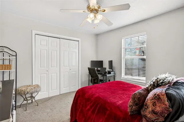 a bedroom with a bed and a flat tv screen on the dresser