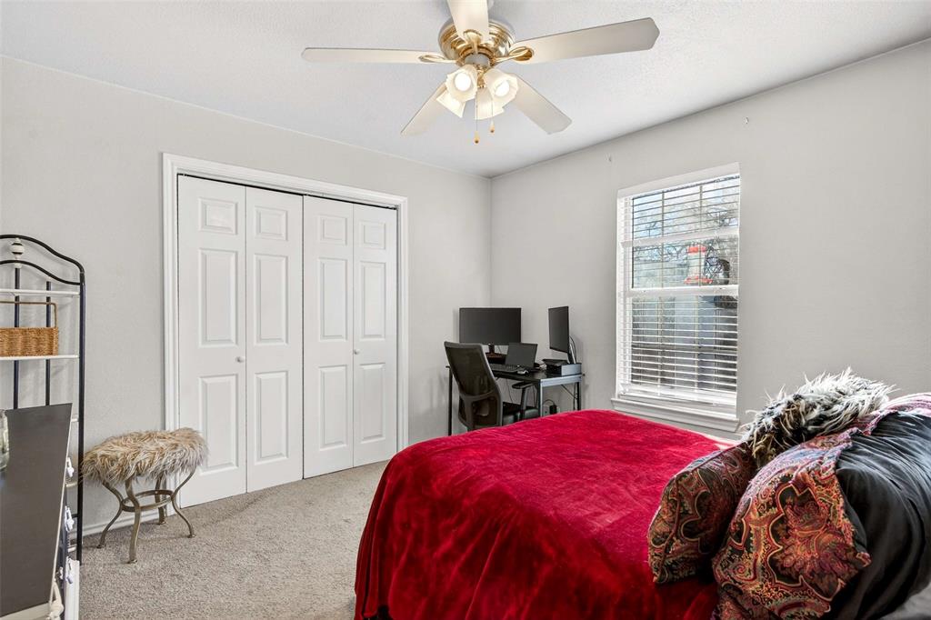 1001 South 4th Street Bonham, TX 75418 - Photo 18 of 27 a bedroom with a bed and a flat tv screen on the dresser