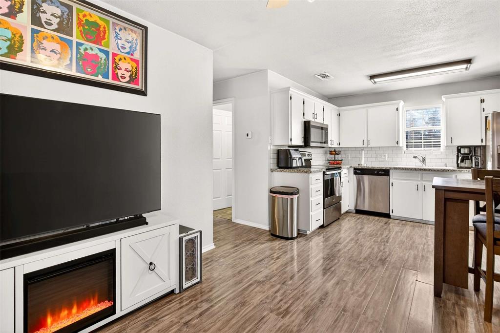1001 South 4th Street Bonham, TX 75418 - Photo 7 of 27 a kitchen with stainless steel appliances a stove top oven a sink and a refrigerator