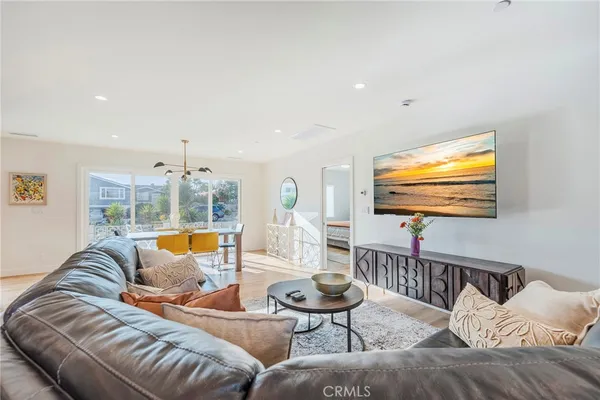 a living room with furniture kitchen view and a large window