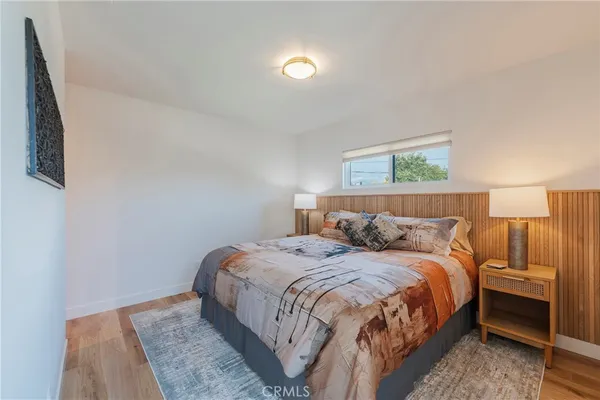 a bedroom with a bed and a lamp on dresser
