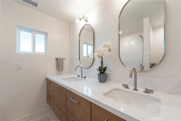 a bathroom with double vanity sinks and a mirror
