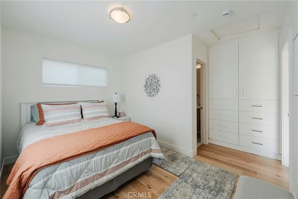 a bedroom with a bed and painting on the wall