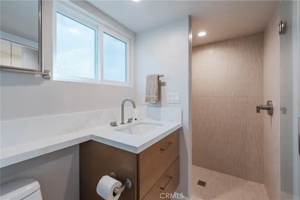 a bathroom with a sink shower and a mirror
