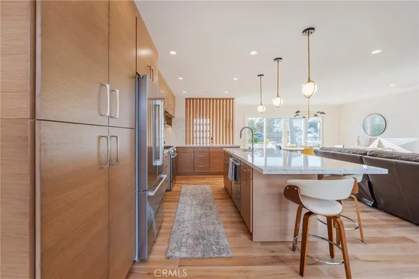 a kitchen with refrigerator and chairs