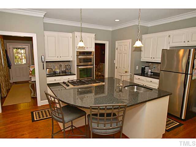 3217 Anderson Drive Raleigh, NC 27609 - Photo 5 of 25 a kitchen with stainless steel appliances granite countertop a table chairs and a refrigerator