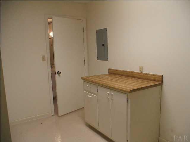 6317 Rice Street Milton, FL 32583 - Photo 12 of 14 Large Laundry Room with Folding Table and extra cabinets.