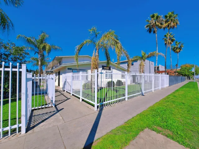 a view of a house with a yard and potted plants