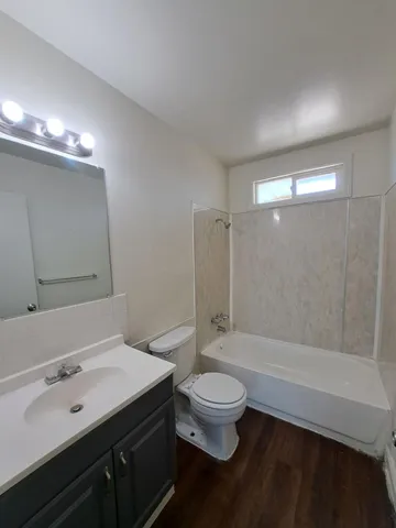 a bathroom with a sink a toilet a mirror and shower