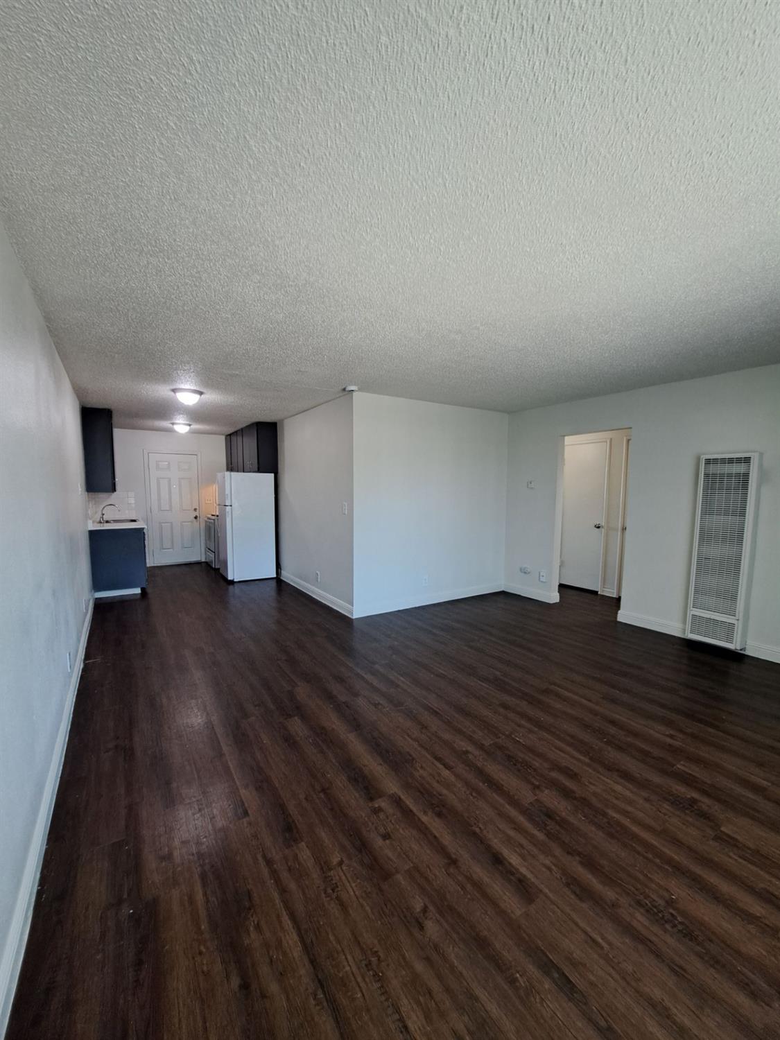 441 South Dearing Avenue Fresno, CA 93702 - Photo 6 of 9 a view of empty room with wooden floor and window