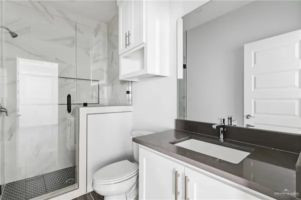 a bathroom with a sink toilet vanity and shower