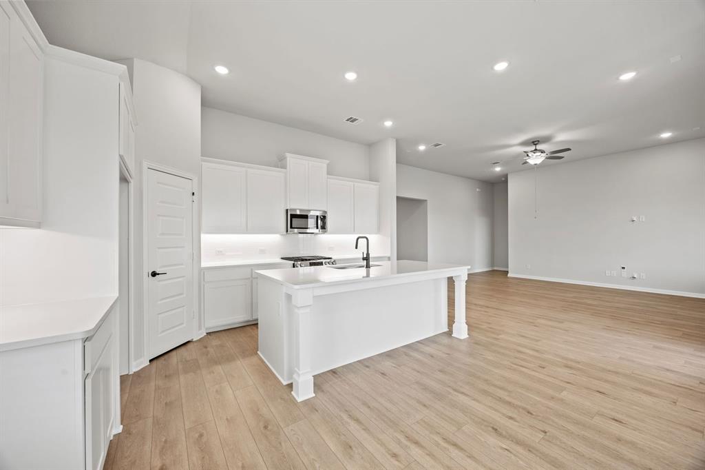 1507 Red Clover Avenue Van Alstyne, TX 75495 - Photo 12 of 30 a kitchen with stainless steel appliances a white stove top oven sink and cabinets