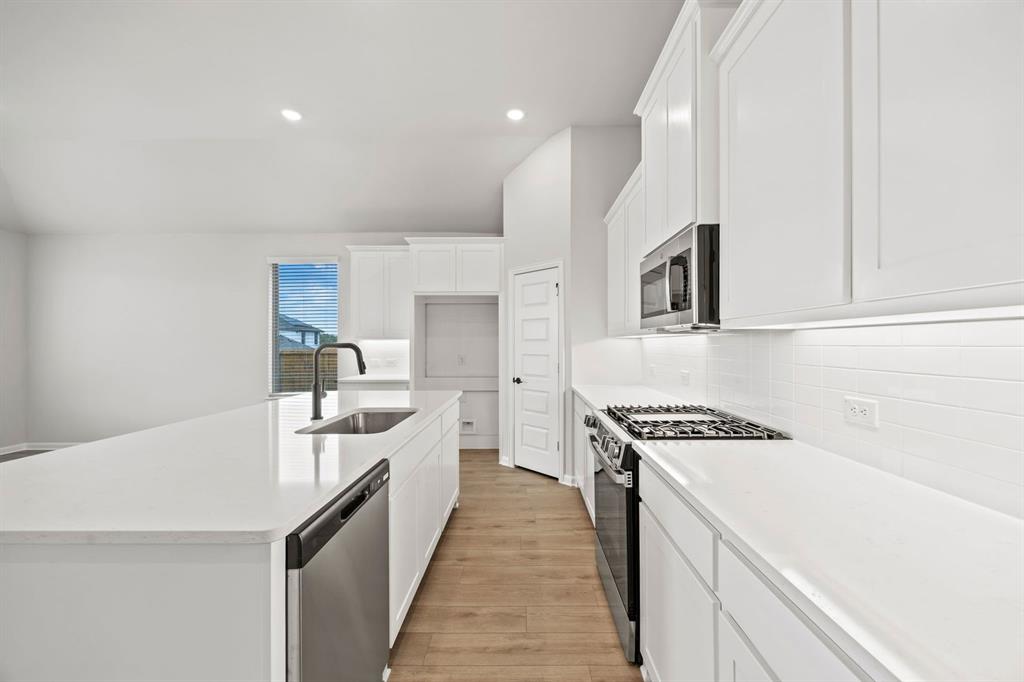 1507 Red Clover Avenue Van Alstyne, TX 75495 - Photo 4 of 30 a kitchen with a sink a stove and cabinets