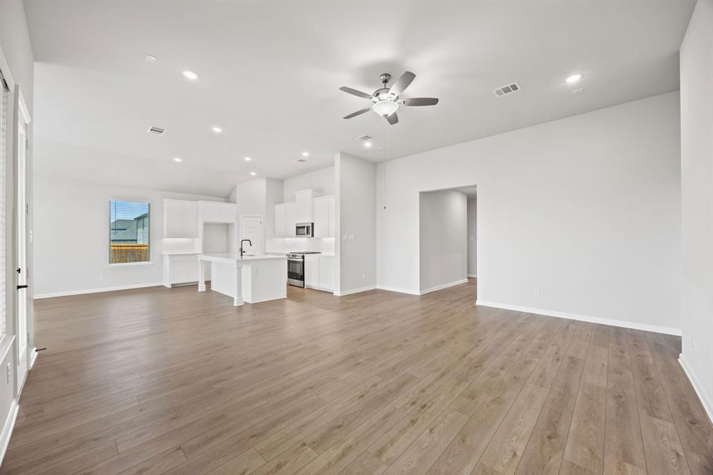 1507 Red Clover Avenue Van Alstyne, TX 75495 - Photo 5 of 30 a view of an empty room with wooden floor and a window