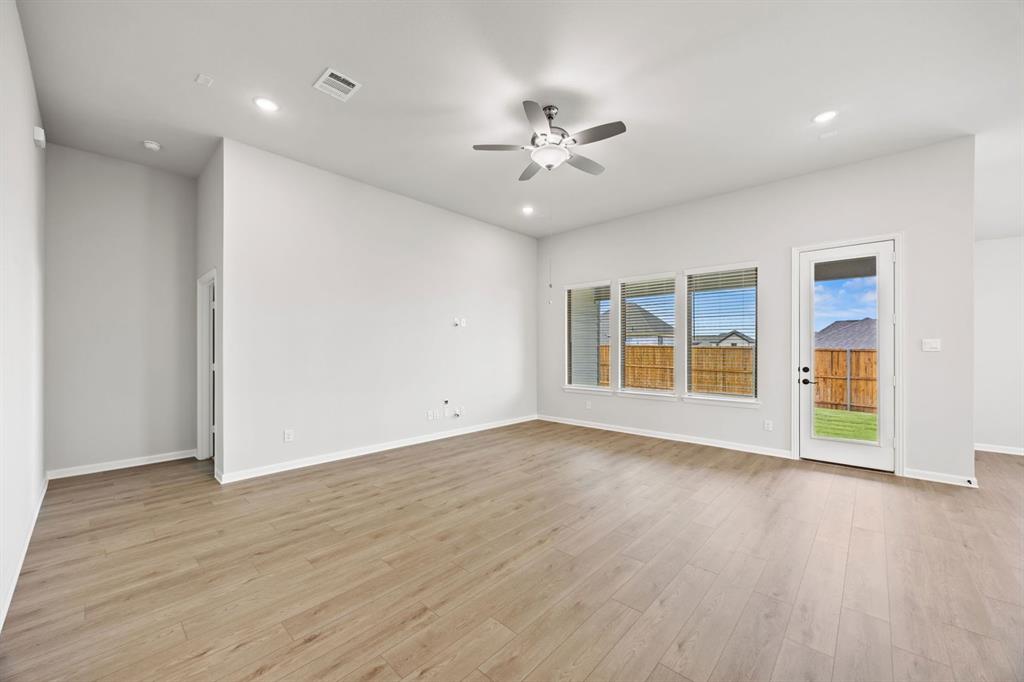 1507 Red Clover Avenue Van Alstyne, TX 75495 - Photo 6 of 30 a view of an empty room with wooden floor and a window