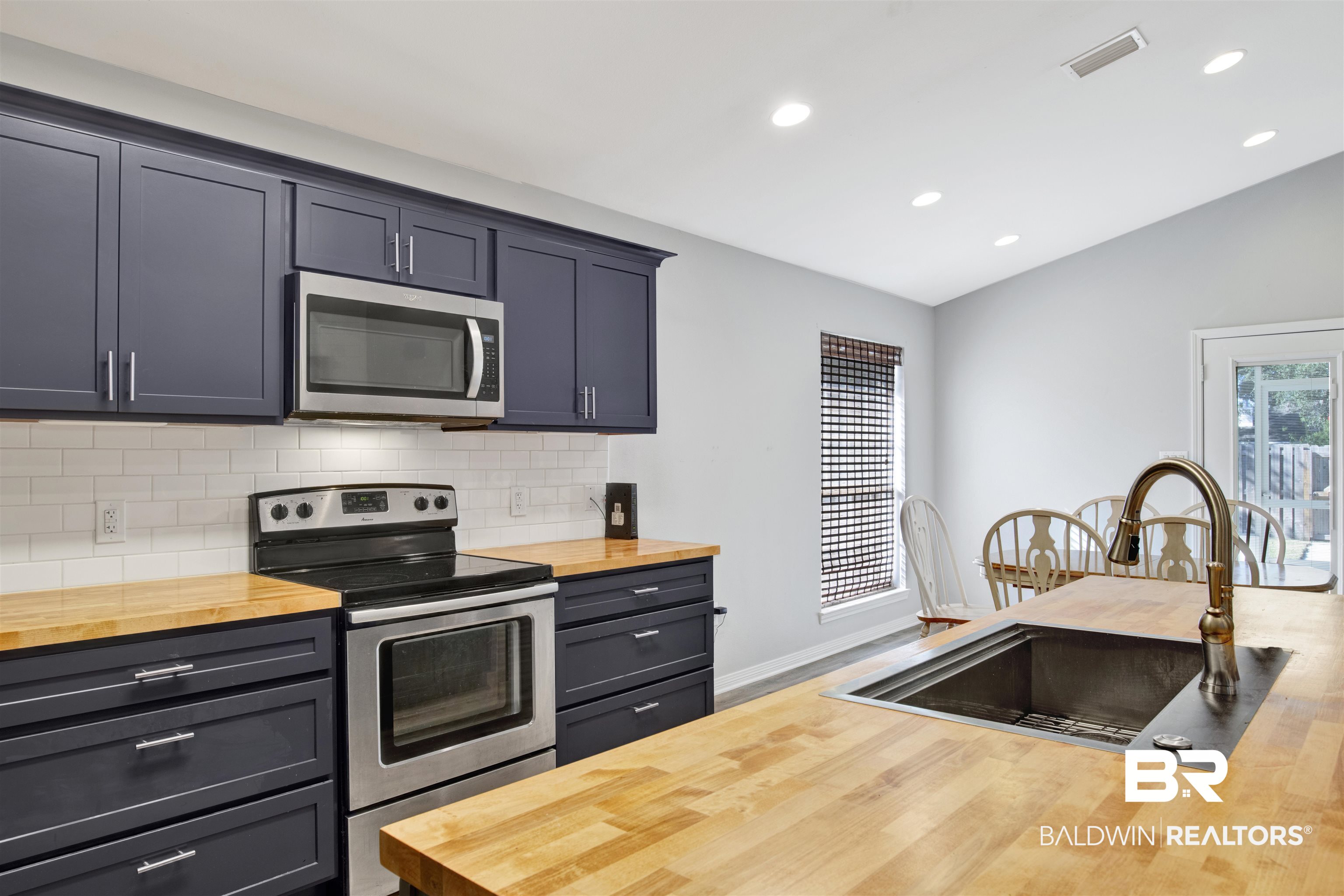 7145 Raintree Lane Gulf Shores, AL 36542 - Photo 8 of 25 Kitchen featuring butcher block counters, sink, stainless steel appliances, hardwood / wood-style floors, and lofted ceiling