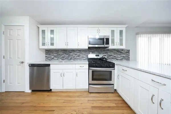 a kitchen with stainless steel appliances granite countertop a stove a sink and a microwave