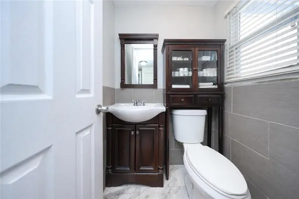 a bathroom with a toilet sink and mirror