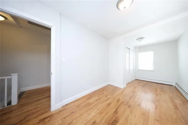 a view of a room with wooden floor and white walls