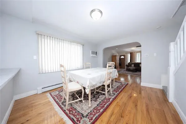 a dining room with wooden floor and window