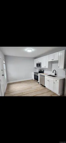 a view of kitchen with cabinets stainless steel appliances and a sink
