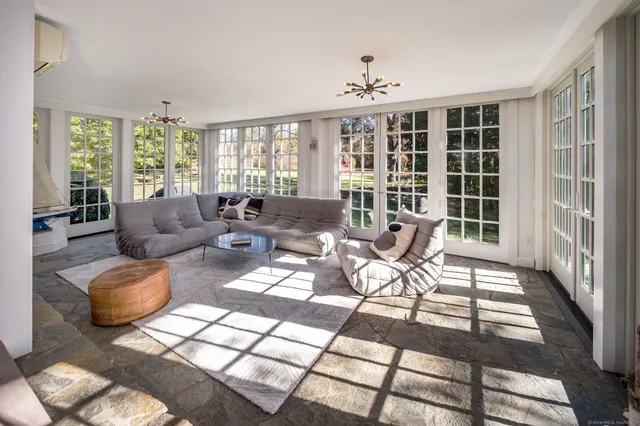 a living room with furniture and floor to ceiling windows