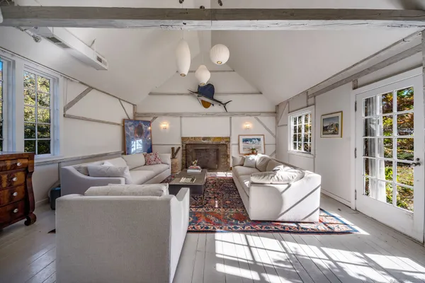 a living room with furniture a fireplace and a chandelier