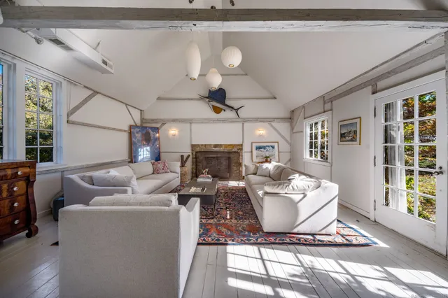 a living room with furniture a fireplace and a chandelier