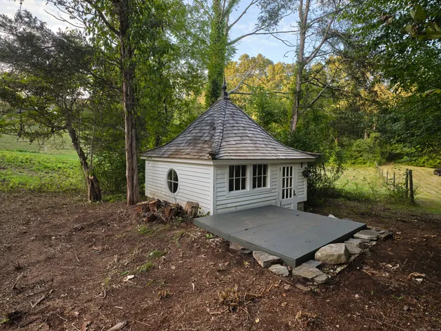 a view of a house with a yard and large trees