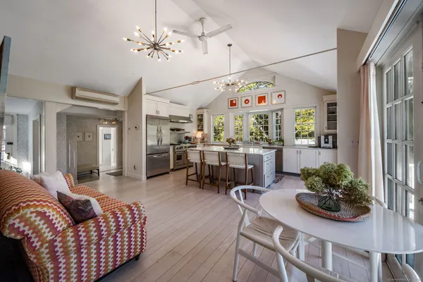 a living room with furniture kitchen and a chandelier