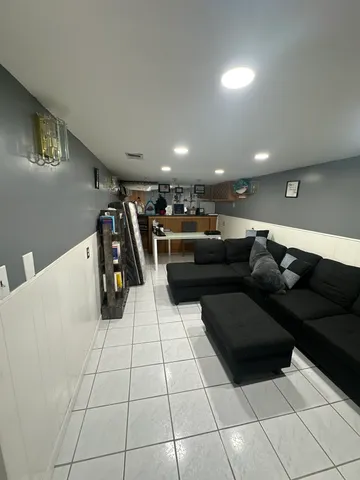 a living room with couches and kitchen view